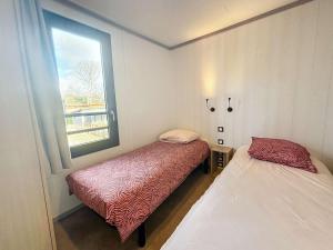 une petite chambre avec deux lits et une fenêtre dans l'établissement Jullouville: Villa 4 pers, proche plage, piscine chauffée - FR-1-361-534, à Jullouville 19 autres photos
