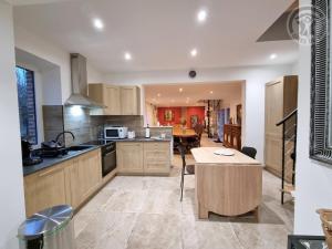 une cuisine avec une table et un comptoir dans l'établissement Charmante maison mitoyenne avec jardin, proche forêt, animaux admis, parking & WiFi - FR-1-510-203, à Hasnon 28 autres photos