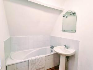 a bathroom with a bath tub and a sink at Gîte spacieux et moderne, à 12 km de Lille, avec toutes commodités, idéale pour une escapade tranquille - FR-1-510-208 in Linselles +13 photos