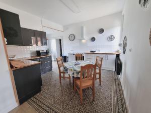 eine Küche mit einem Tisch und Stühlen im Zimmer in der Unterkunft Gîte Sains-du-Nord, 6 pièces, 11 personnes - FR-1-510-204 in Sains-du-Nord