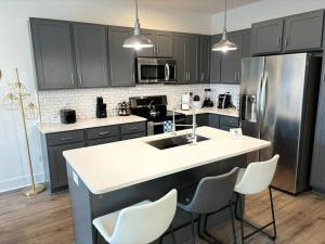 a kitchen with a kitchen island with white counter chairs at Enjoy the Saddle House with your Furry Friends! in Greenville