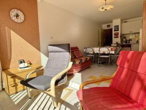uma sala de estar com um sofá e uma cadeira em Appartement Argelès-sur-Mer, 2 pièces, 6 personnes - FR-1-225-806 em Argelès-sur-Mer
