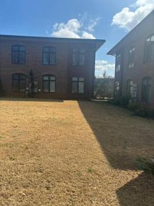 a large brick building with a yard in front of it at Enjoy the Saddle House with your Furry Friends! in Greenville
