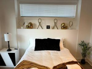 1 dormitorio con 1 cama blanca con ventana y aigunigunigun en Enjoy the Saddle House with your Furry Friends!, en Greenville