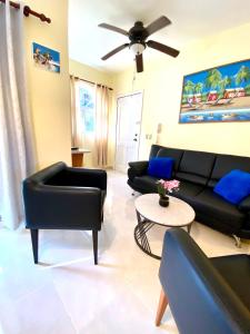 uma sala de estar com mobiliário preto e uma ventoinha de tecto em paradise close to the beach pool free parking,wifi- punta cana em Punta Cana