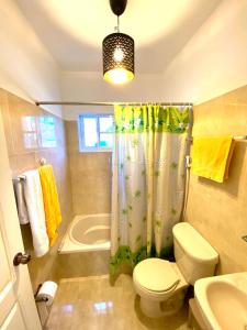uma casa de banho com um WC e uma cortina de chuveiro em paradise close to the beach pool free parking,wifi- punta cana em Punta Cana