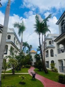 uma passagem entre dois edifícios com palmeiras em paradise close to the beach pool free parking,wifi- punta cana em Punta Cana