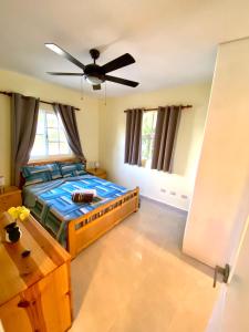 een slaapkamer met een bed en een plafondventilator bij paradise close to the beach pool free parking,wifi- punta cana in Punta Cana