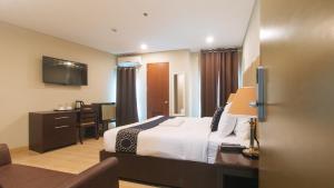 a hotel room with a bed and a desk at Asrodel Hotel RedPartner in Davao City