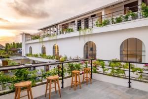 een balkon van een gebouw met stoelen en planten bij Mysa Boutique Hotel in Seminyak