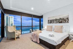 1 dormitorio con 1 cama grande y 1 silla en High Floor Ocean Views - Circle on Cavill - Wow Stay en Gold Coast