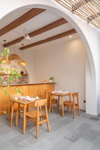 uma sala de jantar com mesas e cadeiras de madeira em Mysa Boutique Hotel em Seminyak