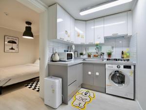 a small kitchen with a washer and dryer at Hygge - Urban Hideout with four comfort beds in Seoul