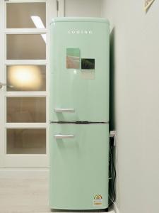a white refrigerator in a kitchen next to a cabinet at Hygge - Urban Hideout with four comfort beds in Seoul