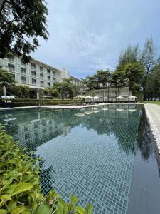 a swimming pool in front of a building at Lone Pine, Penang, a Tribute Portfolio Resort in Batu Ferringhi