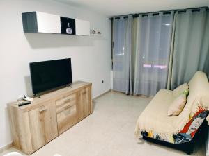 a living room with a flat screen tv on a wooden cabinet at apartamento moderno in Benidorm