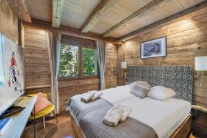 a bedroom with two beds in a room with wooden walls at SOMPTUEUX CHALET BARON MEGEVE VUE.Jaccuzi.4 mn a pied au centre in Megève