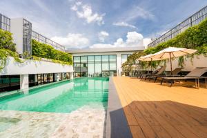 a swimming pool with two umbrellas in a building at Amanta Hotel & Residence Sathorn in Bangkok