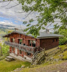 a wooden house on top of a hill at SOMPTUEUX CHALET BARON MEGEVE VUE.Jaccuzi.4 mn a pied au centre in Megève