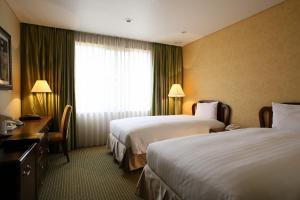 Cette chambre comprend 2 lits et une fenêtre. dans l'établissement International Resort Hotel Yurakujo, à Narita