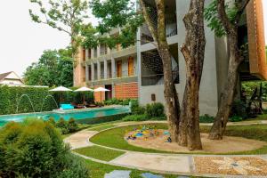an apartment building with a swimming pool and a garden at Proud Phu Fah Muang Chiang Mai in Chiang Mai