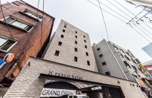 un grand bâtiment en briques avec un panneau sur celui-ci dans l'établissement H Hotel Wangsimni, à Séoul