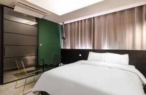 a bedroom with a large white bed and a green wall at H Hotel Wangsimni in Seoul
