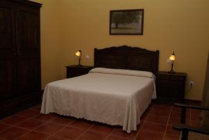 a bedroom with a bed and two lights on the wall at Casa Rural Las Canteras in Trujillo