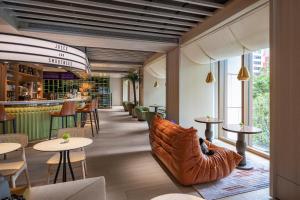 台北市にあるHumble Boutique Hotelの革張りのソファ、テーブル、椅子が備わるレストラン