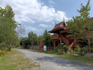 a building with a roof on the side of a road at บ้านสวนคุณปาน เขาใหญ่ Ban Suan Kun Parn Khao Yai in Mu Si