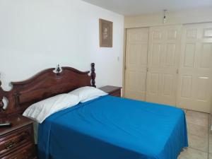 ein Schlafzimmer mit einem blauen Bett und einem Schrank in der Unterkunft Estancia Santa Fe in Celaya