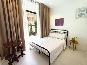 a bedroom with a bed and a table and a window at JD&S Apartments Unit 2 in Iligan City