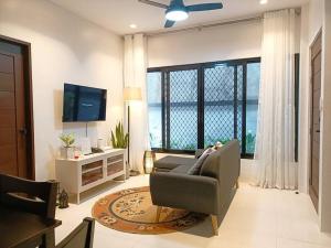 uma sala de estar com um sofá e uma televisão em JD&S Apartments Unit 2 em Iligan