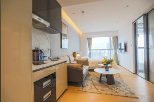 a kitchen and living room with a couch and a table at Yuexi Executive Apartment - Futian Zhongzhouwan in Shenzhen