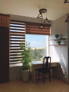 Zimmer mit einem Tisch und einem Fenster mit einer Pflanze in der Unterkunft Khách Sạn 20-10 in Dong Hoi
