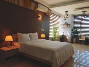 una camera da letto con un grande letto con due lampade sopra di Khách Sạn 20-10 a Dong Hoi