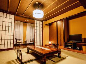 a living room with a table and a television at Toeikan in Shibata