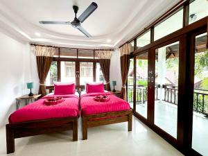 une chambre avec deux lits et un ventilateur de plafond dans l'établissement Amara Beach Resort Koh Phangan, à Haad Yao 37 autres photos