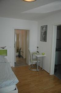 a room with a bed, chair, table and a lamp at Köln Appartement in Cologne