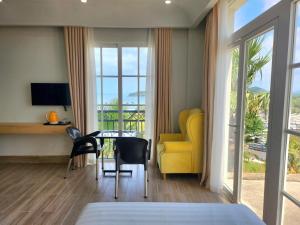 1 dormitorio con sofá amarillo, mesa y sillas en Hi Beach House Phu Quoc - Sunset Town en Phu Quoc