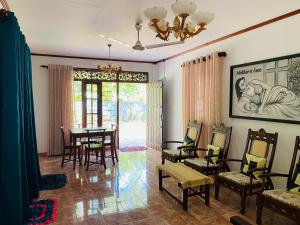 a living room with a table and chairs and a chandelier at Ran Villa in Galle