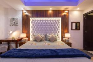 a bedroom with a large bed with a large headboard at Luho C103 in Dehradun