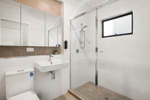 a bathroom with a shower and a toilet and a sink at Clare St Apartments by Urban Rest in Port Adelaide