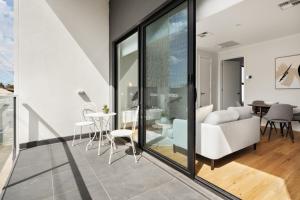 a living room with glass doors and a dining room at Clare St Apartments by Urban Rest in Port Adelaide