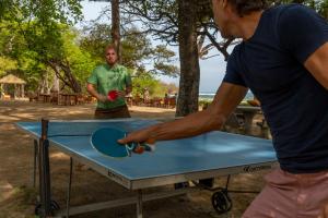 two men playing ping pong on a ping pong table at Capitán Suizo Beachfront Boutique Hotel in Tamarindo