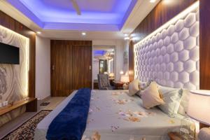 a bedroom with a large bed with a blue ceiling at Luho C103 in Dehradun