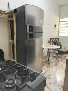 a kitchen with a stainless steel refrigerator and a stove at Casa E-House Manaus in Manaus