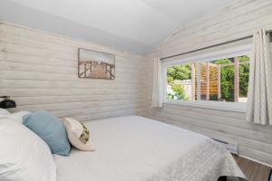a bedroom with a bed and a window at Lake Time Harrison in Harrison Hot Springs