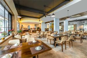 jadalnia ze stołami, krzesłami i oknami w obiekcie Amon Hotel Phu Quoc w Duong Dong
