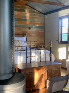 a bedroom with a bed with a wooden wall at Creek Shack - Off Grid in Glen Innes